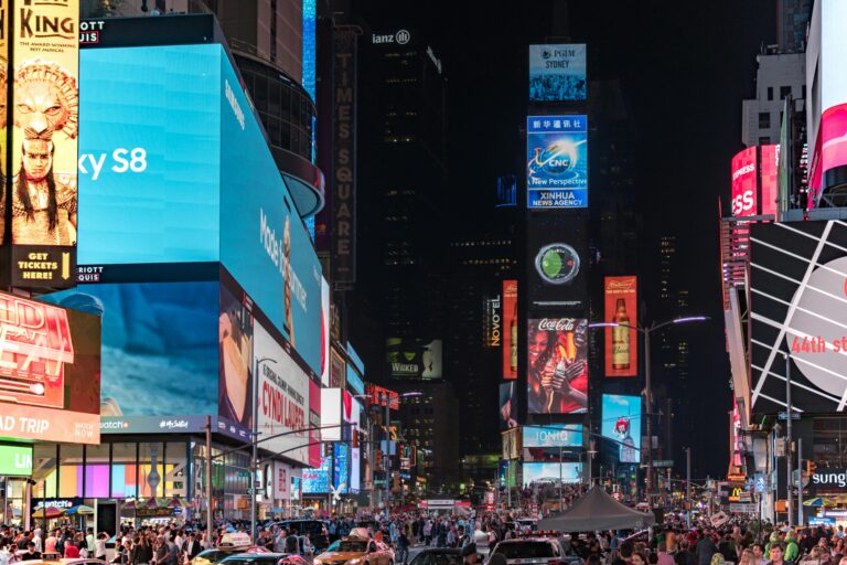 Bustling Times Square at night, showcasing bright billboards and crowds in New York City.